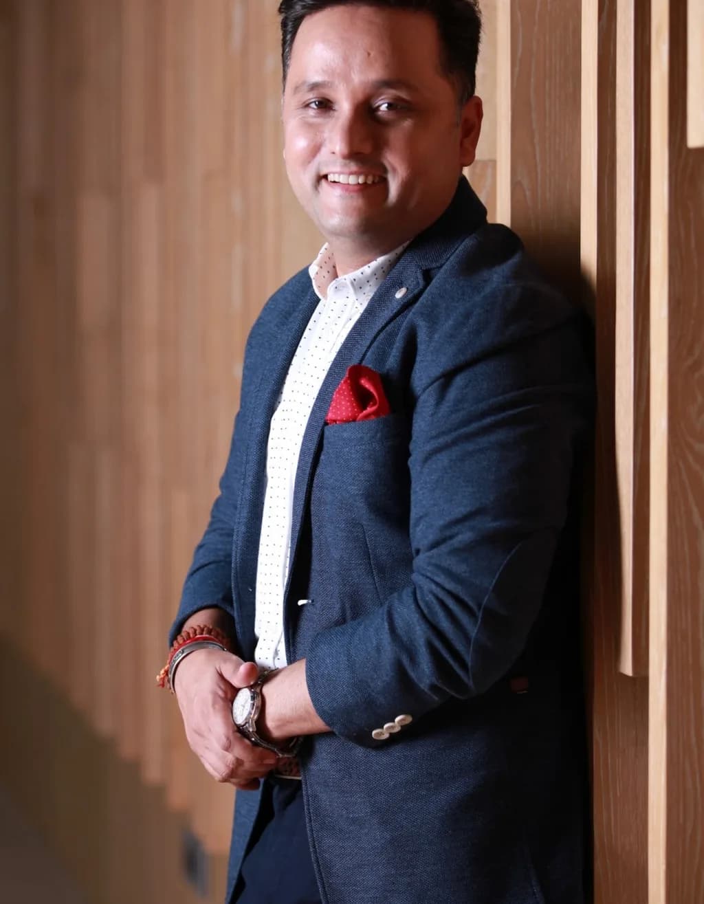 Amish Tripathi, portrait in a dark suit, standing in a library